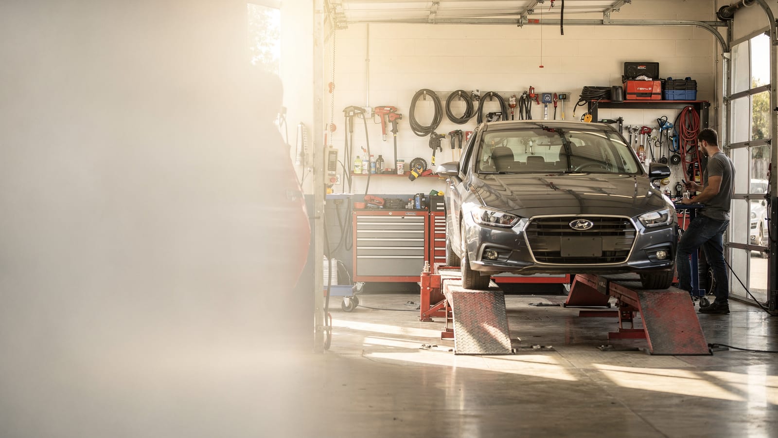 A car up on the lift in a sunlit repair bay at Fed's Auto